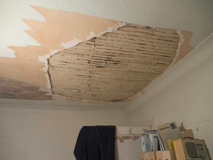 Collapsed ceiling exposing laths after a water leak in a home